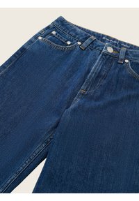 Vaqueros de pierna recta en azul, fabricados con denim, que presentan un diseño clásico de cinco bolsillos, costuras de cobre y detalles en botón plateado en la cintura.