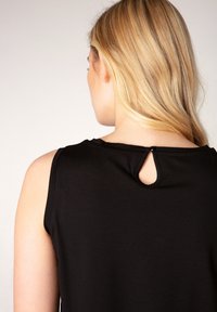 Schwarzes ärmelloses Oberteil mit rundem Ausschnitt und kleinem Schlüsselloch-Detail am Rücken, gefertigt aus weichem, glattem Stoff.