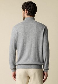 Maglione grigio lavorato a maglia con colletto alto, polsini e orlo a coste. Tessuto liscio, vestibilità casual e design classico. Nessun motivo o accessorio visibile.