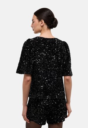 Haut noir à sequins avec manches courtes évasées, doté d'un col rond et d'une coupe ample. Texture scintillante couvrant l'ensemble du vêtement.