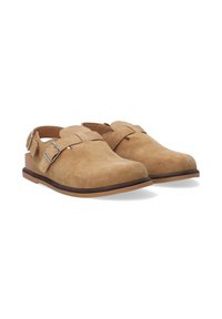 Tan suede slingback sko med rund tå, justerbar spænde rem og flad gummisål. Minimalistisk design med glat tekstur.