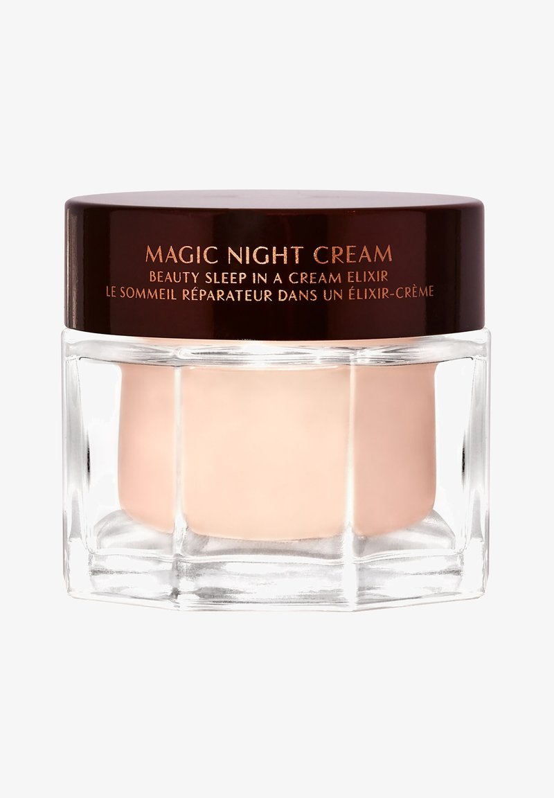 Glasgefäß mit Magic Night Cream, dunklem braunem Deckel und dem Text "Beauty Sleep in a Cream Elixir" auf Englisch und Französisch auf dem Deckel.