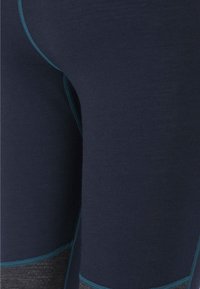 Marinblå leggings med kontrasterande teal-sömmar och texturerade grå accenter. Slim fit, slät tyg med stretch för komfort.
