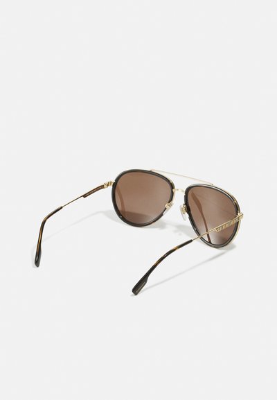 Brunefargede solbriller med gullfarget metallramme, dobbel brow bar, og skilpaddeaktige detaljer på brow og tempeltips. Glanset finish.