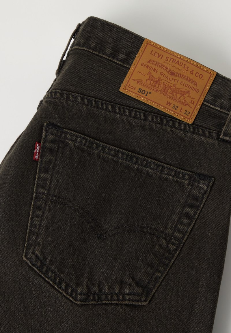 Baglomme på sorte Levi's 501 jeans, der viser det brune læder Levi Strauss-mærke og den røde Levi's stofmærke.