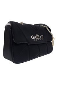 Borsa a tracolla nera in pelle con motivo trapuntato, tracolla in catena argentata e logo metallico con la scritta "Gaëlle Paris" sul davanti.