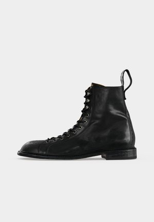 Schwarzer hoher Lederstiefel mit Schnürung vorne, Brogue-Details auf der Zehenkappe, Zuglasche an der Ferse und niedrigem Blockabsatz.