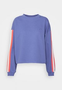 Sweatshirt viola a maniche lunghe con strisce rosse e bianche lungo le maniche e un piccolo logo a forma di cuore sul petto.