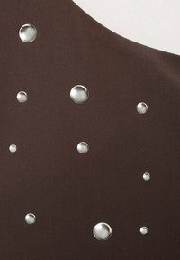 Tissu marron présentant des bulles métalliques de tailles variées disposées de manière asymétrique, mettant en valeur la texture et les finitions contrastées.