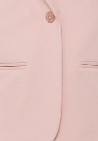 Veste rose pâle à l'avant avec un seul bouton assorti et deux poches fendues horizontales.