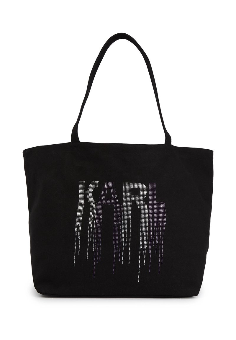 Svart tote-väska i mjukt tygmaterial. Har en stor design med droppande rhinestones som stavat "KARL" i lila och silver nyanser.