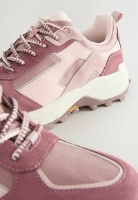 Rosa und mauve Sport Schuhe mit einem Obermaterial aus Wildleder und Mesh, strukturierten Akzenten, gepolstertem Kragen und einer Gummisohle mit Traktionsnoppen.