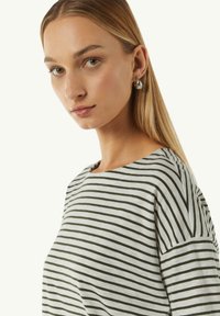 Gestreept t-shirt in grijs en donkergroen katoen met een bootnek. Gladde textuur en relaxed fit, met een klein zijlabel detail.