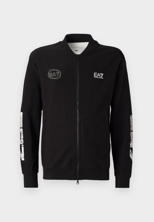 Black zip-up jacket made of smooth fabric. Features a stand-up collar, ribbed cuffs, and bold white graphic detailing on sleeves and chest.