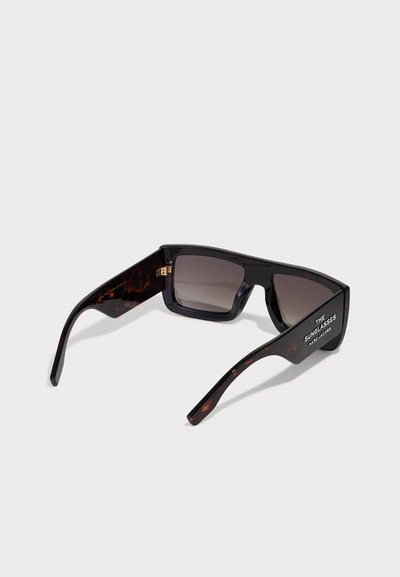 Ochelari de soare negri cu un cadru rectangular, lentile întunecate cu gradient și accente de broasca țestoasă pe brațe; prezintă branding pe lateral.