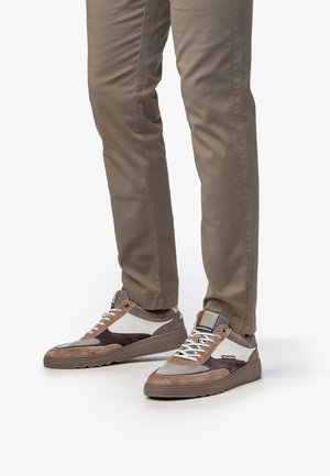 Baskets marron et grises en matériaux suede et mesh, avec un accent blanc, des lacets texturés et une semelle en caoutchouc durable.
