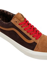 Zapatillas de ante marrón con detalles en color beige, cordones rojos trenzados, suela de goma blanca y forro interior a rayas. El diseño presenta franjas laterales curvas.