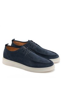Scarpe in suede blu navy con suola chiara, dotate di lacci e dettagli di cucitura lungo i bordi. Forma della punta arrotondata e texture liscia.