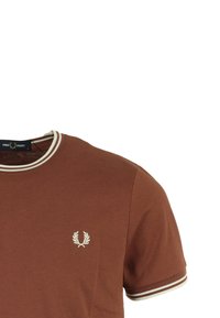 T-shirt in cotone marrone con colletto rotondo, dettagli a strisce bianche e piccolo logo ricamato sul lato sinistro del petto. Texture morbida. Maniche corte.