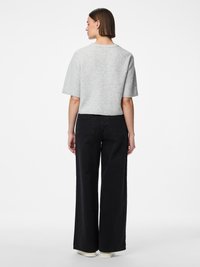 Helehall lühikeste varrukatega kampsun, mis on ühendatud kõrge vöökohaga mustade laiade pükstega. Pükstel on klassikaline tagatasku disain ja kontrastne õmblus.