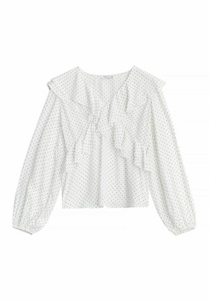 Hvid bluse med lange ærmer og små sorte polkaprikker, med en flæset V-udskæring og elastiske manchetter.