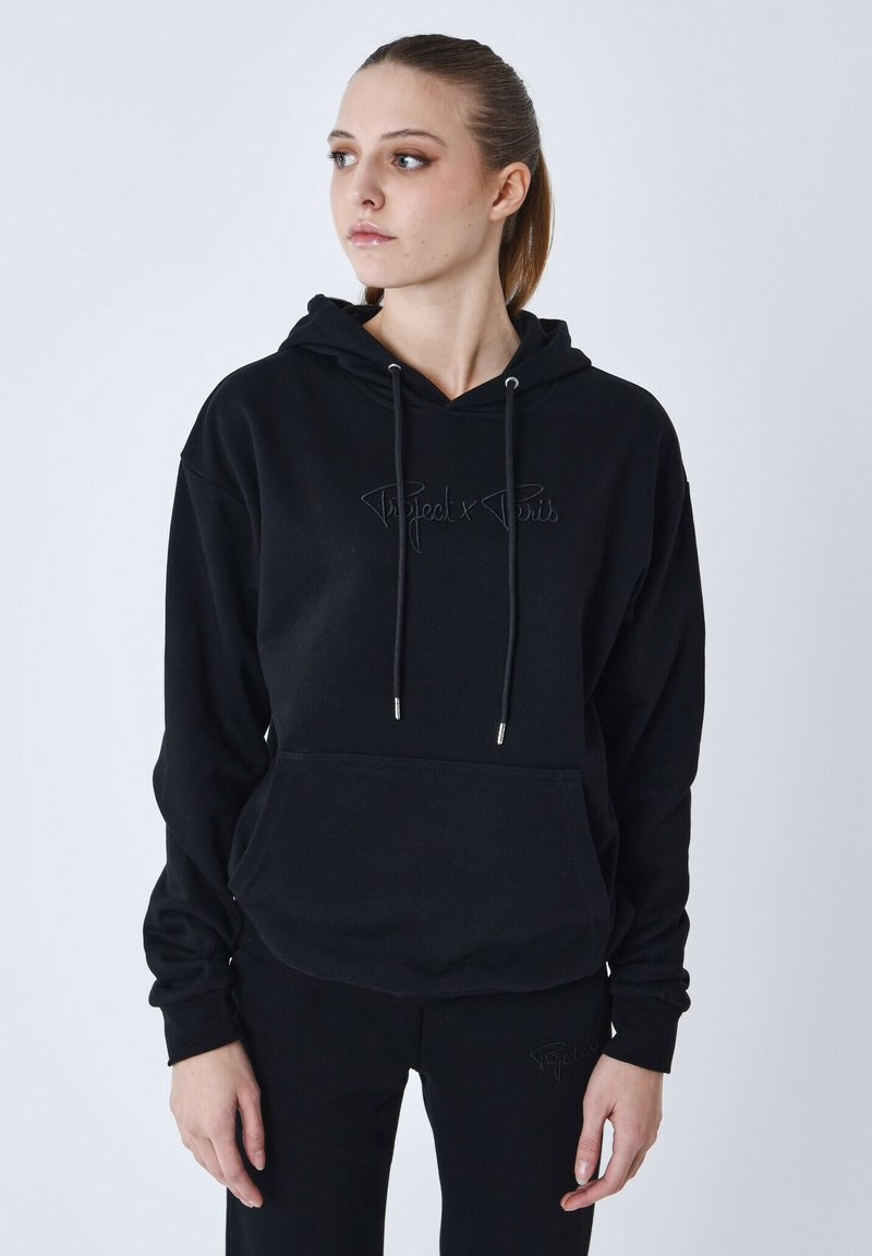 Hoodie noir avec une poche kangourou, cordons argentés et logo brodé. Tissu doux, coupe décontractée, poignets côtelés et ourlet.