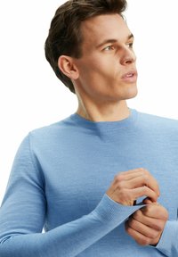 Pull léger bleu, à manches longues, avec un col rond, fabriqué en matériau doux. Présente des poignets côtelés et une texture lisse.