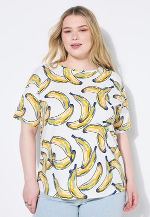 T-shirt bianco a maniche corte con una stampa di banane colorata in giallo e blu. Il design è giocoso con una vestibilità ampia e rilassata.