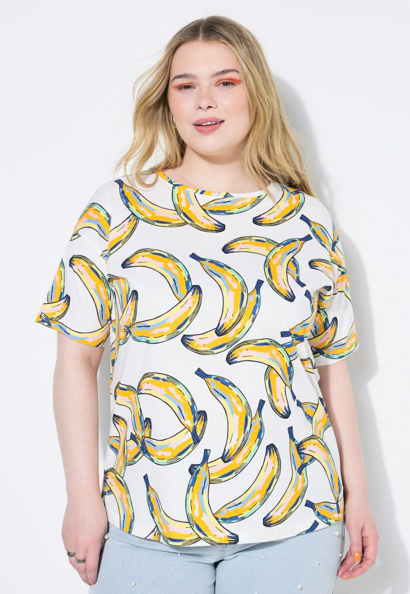Camiseta blanca de manga corta con un estampado colorido de plátanos en amarillo y azul. El diseño es juguetón y tiene un corte suelto y relajado.
