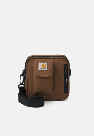 Braune rechteckige Crossbody-Tasche mit vorderer Klappentasche, vertikaler Reißverschlusstasche, schwarzem verstellbarem Riemen und Carhartt-Logo-Patch.