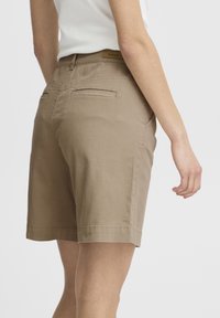 Shorts en coton beige avec une coupe droite, taille mi-haute, deux poches arrière et ourlet fini. Étiqueté "fransa".
