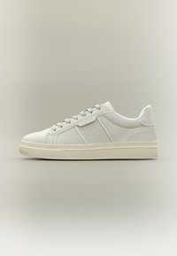 Hvide lædersneakers med diskret tekstur, rund tå og flade snørebånd. Har en tekstureret sidepanel og en lys gummisål.