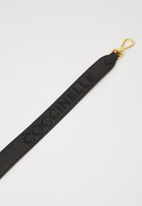 Black leather strap with embossed "COCCINELLE" logo, featuring a gold metal clip for attachment. Smooth texture with a subtle sheen.
