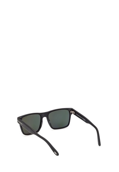 Lunettes de soleil rectangulaires noires avec verres teintés foncés et branches épaisses, inclinées pour montrer l'intérieur de la monture et des branches.