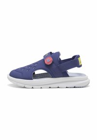 Lilla sandal med perforeret overdel, justerbar rem og lyserød knapdetalje. Har en tyk hvid sål med tekstureret greb.