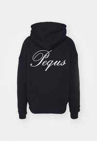 Fekete kapucnis pulóver, zsinórral és elülső zsebbel. A "Pequus" nagy, fehér, írott betűkkel van felírva a hátsó részén. Puha anyagú.