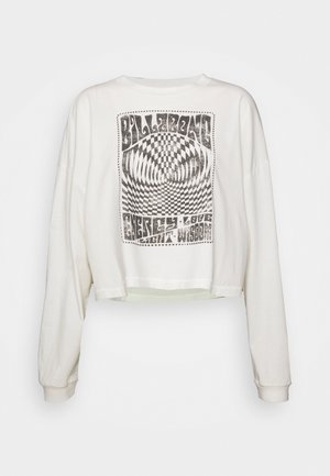 Hvid langærmet cropped sweatshirt med sort psykedelsk skakternet design og tekst, der lyder "Billabong" og "Energi, Kærlighed, Lys, Visdom."
