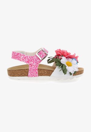 Sandale enfant avec bride cheville pailletée rose, semelle en liège et grandes fleurs décoratives en tissu blanc, rose et bleu sur la bande des orteils.