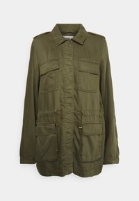 Veste style militaire vert olive en tissu léger. Comprend deux poches poitrine, deux poches avant, et une taille réglable avec cordon de serrage.