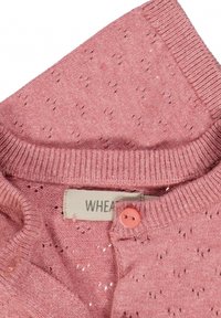Jasnoróżowy sweter dzianinowy o teksturowanym wzorze, z podwójnym kołnierzem, pojedynczym zapięciem na guzik oraz wplecioną metką.