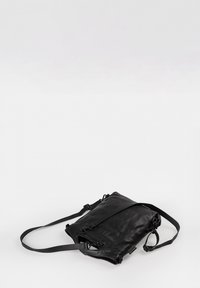 Zwarte leren crossbody tas met verstelbare schouderband, ritssluiting en een zachte textuur. Compact rechthoekig van vorm met subtiele hardware accenten.