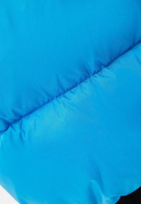 Jasně modrá péřová bunda s hladkým, lesklým povrchem. Obsahuje prošívaný šev podél středu, který ukazuje prošívanou texturu.