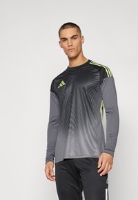 Sportieve lange mouwen shirt in een gradiënt grijs met zwarte en neon groene accenten, met een gebogen patroon en drie strepen op de schouders.