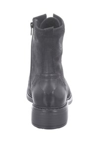 Černá kotníková bota kombinující semiš a kůži, se zipem na boku, kulatou špičkou a patou typu stacked.