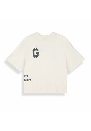 T-shirt oversize couleur blanc cassé avec un "G" pixelisé noir et un texte partiel noir "ET NEY" sur le devant, manches courtes et encolure ronde.