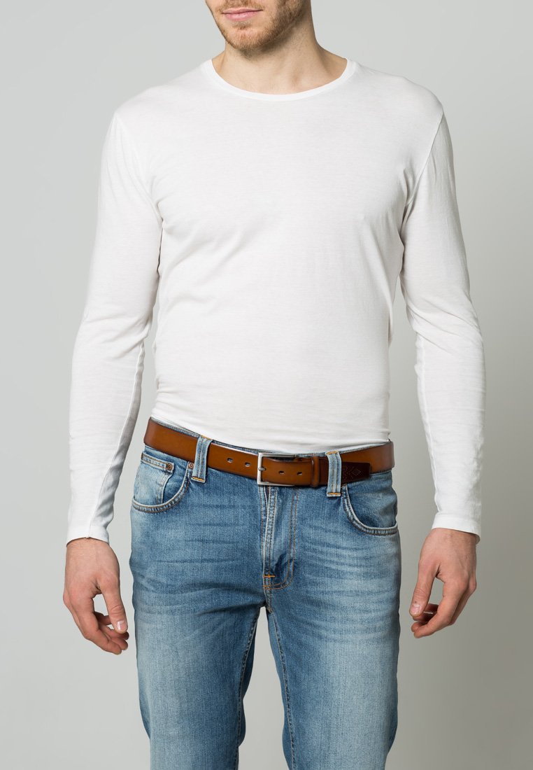 White long-sleeve shirt made of cotton, paired with light blue denim jeans and a brown leather belt. Simple design with a round neckline.