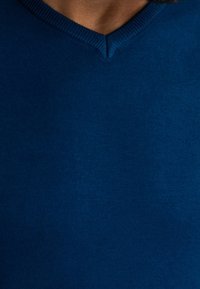 Blauer, strukturierter V-Ausschnitt-Pullover mit geripptem Kragen. Das Material wirkt weich, mit einer gleichmäßigen Farbe und dezentem Glanz.