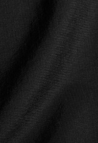 Svart tyg med subtil lyster och fin textur, som visar mjuka veck och ljusreflektioner.