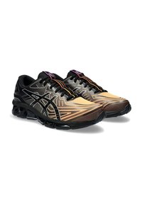 Chaussures de course avec une tige en mesh dégradé orange à noir, dotées d'une semelle extérieure noire et de lacets multicolores. Design épuré pour le sport.