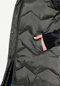 Dunkelgraue Pufferjacke mit einem Chevron-Steppdesign, Reißverschluss und einer Seitentasche. Verfügt über eine glänzende, glatte Textur und schwarze Strickbündchen.